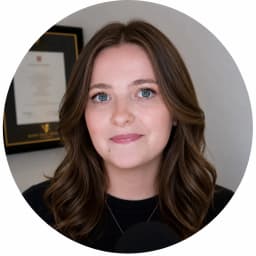 Professional headshot of Ellie Sleightholm, mathematician and online calculator developer, smiling in a clean office setting with neutral background